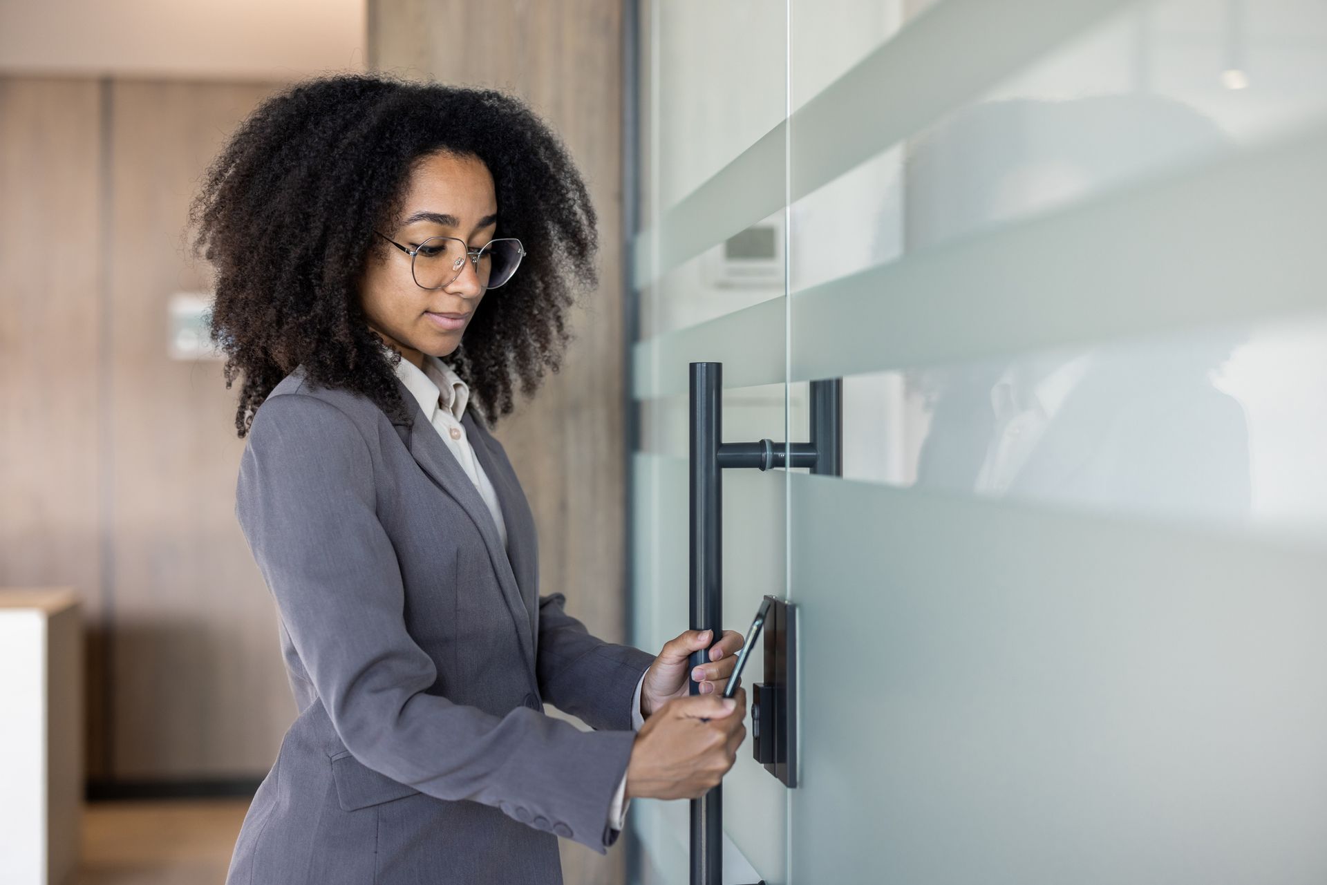 A young African American businesswoman enters her office through an electronic key