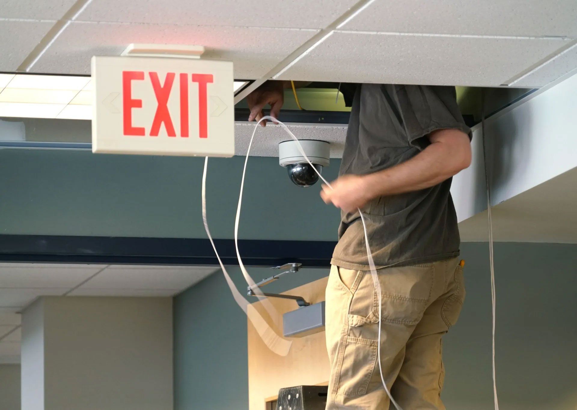 Man Checking Cables in The Ceiling — Houston, TX — Dixie Safe & Lock Service Inc.