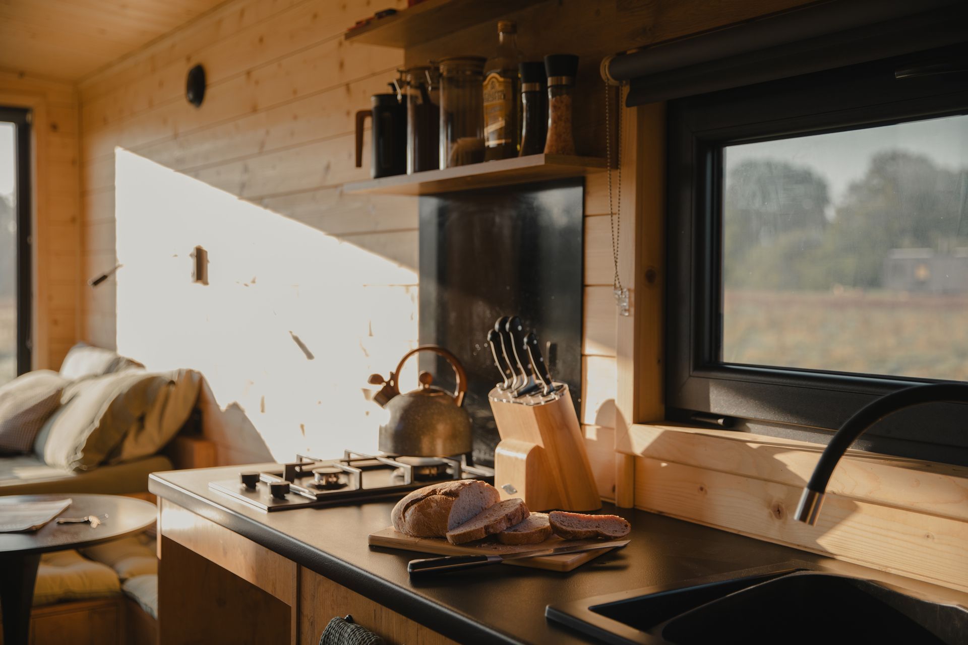 Rustic cabin kitchen with breakfast laid out – wooden counters, coffee, and bread in off-grid cabin.