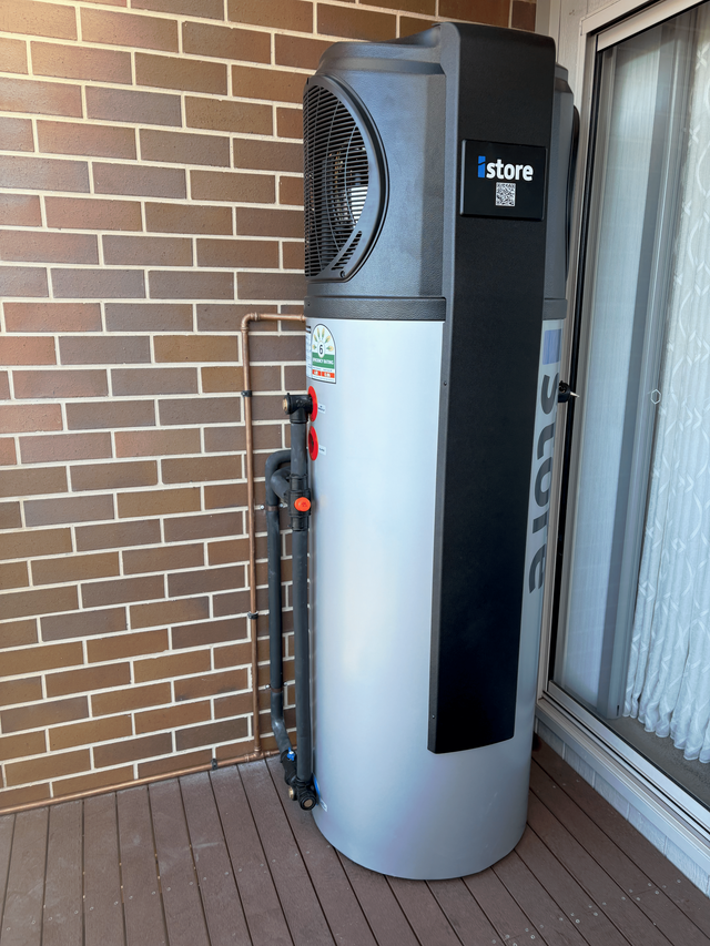 A gray and black water heater with a fan on top of it