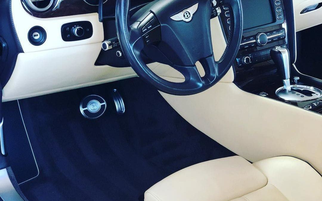 The interior of a bentley car with a steering wheel