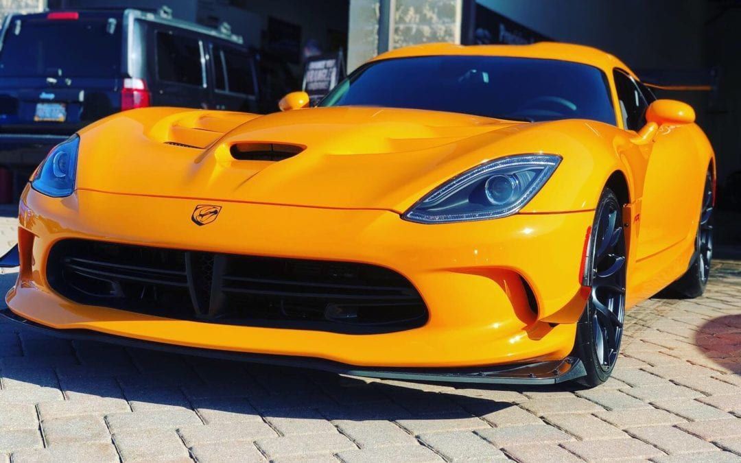 A yellow sports car is parked in front of a garage.