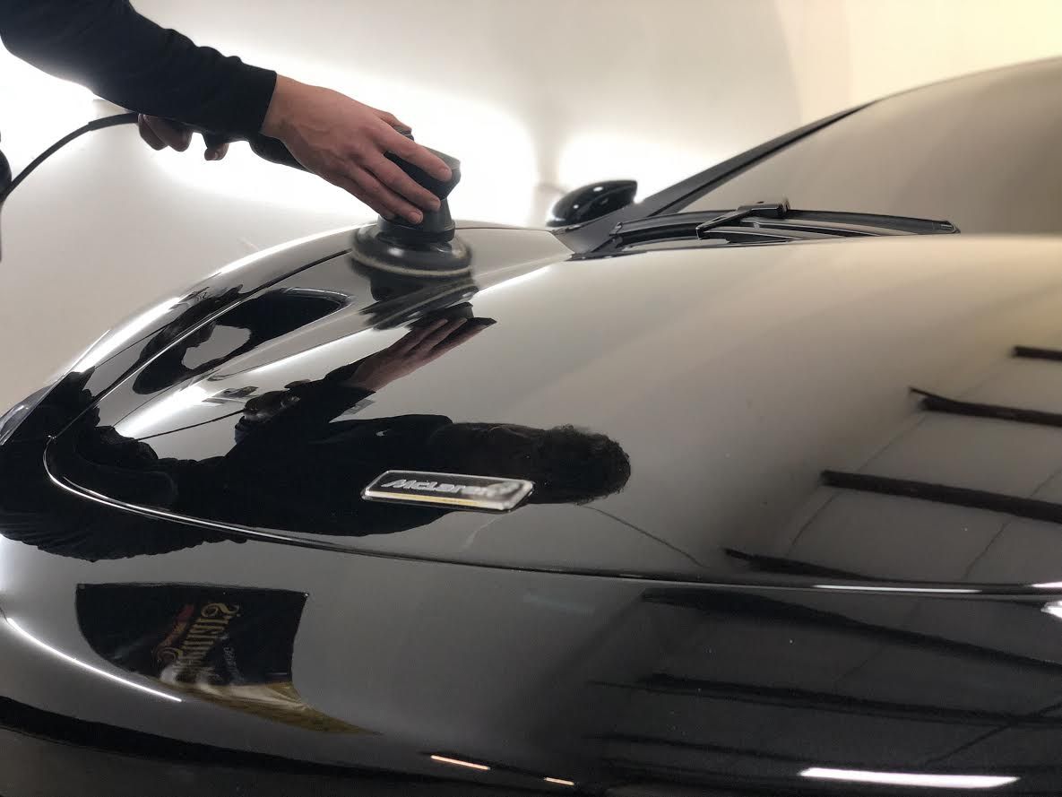 A person is polishing the hood of a car A person is polishing the hood of a car