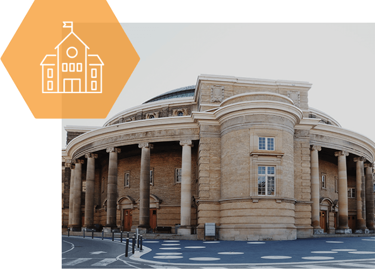 A large building with columns and a flag on top of it.
