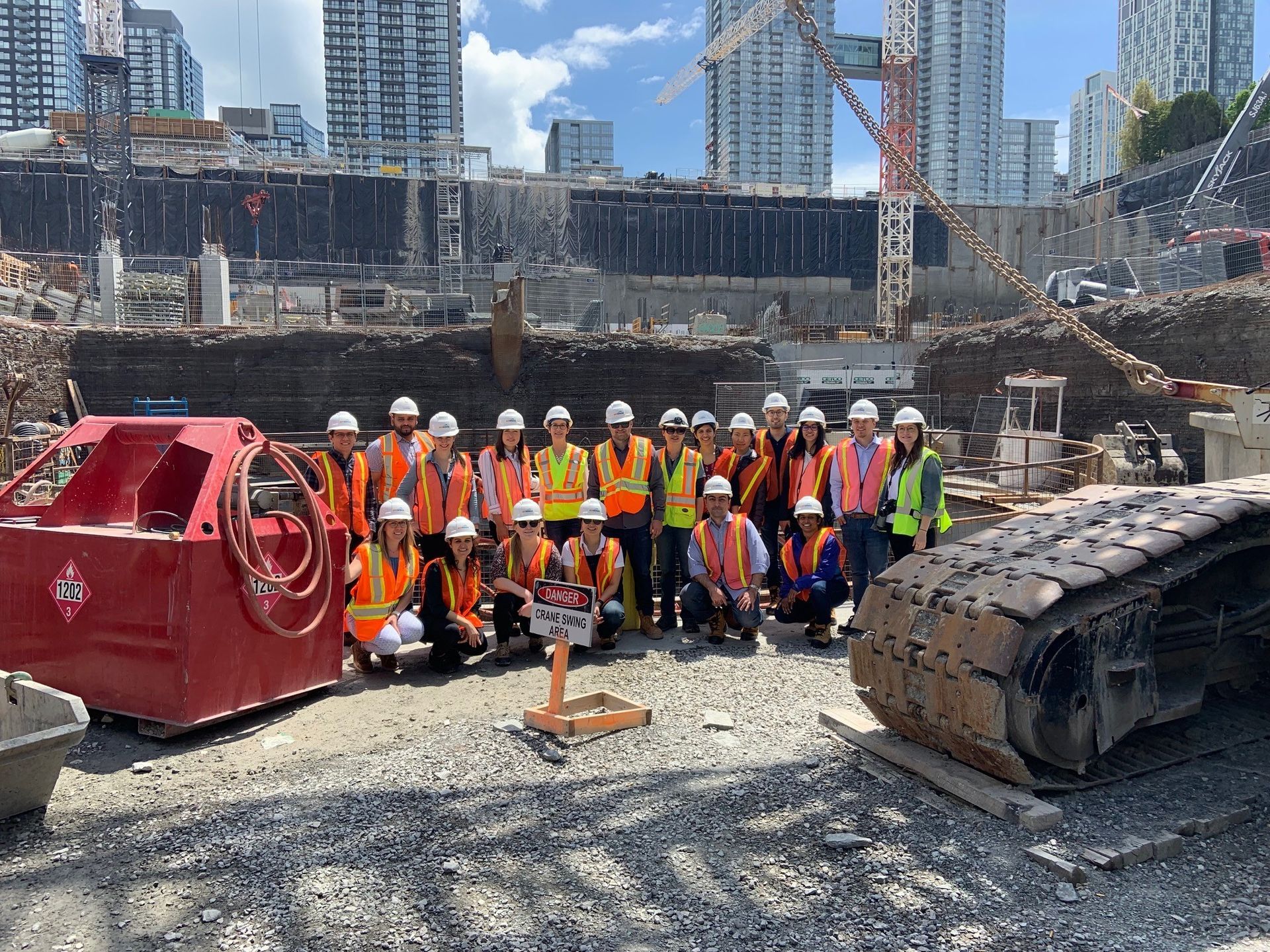 A group of construction workers are posing for a picture at a construction site.