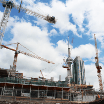 A construction site with cranes and buildings in the background
