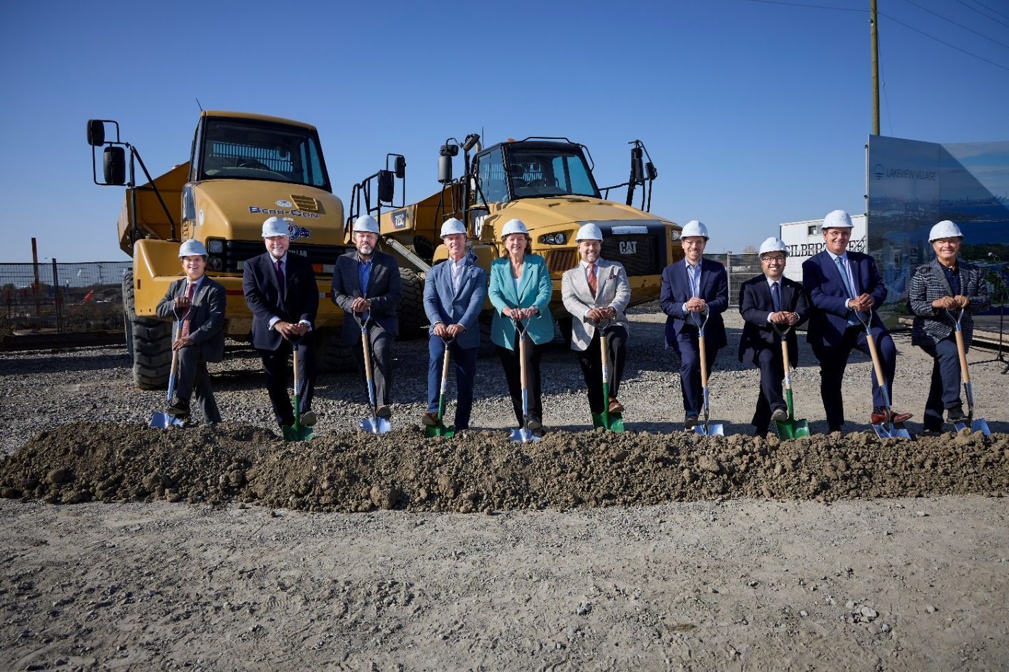 A group of people standing next to each other with shovels.