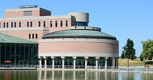 A large building with a dome roof is sitting next to a body of water.