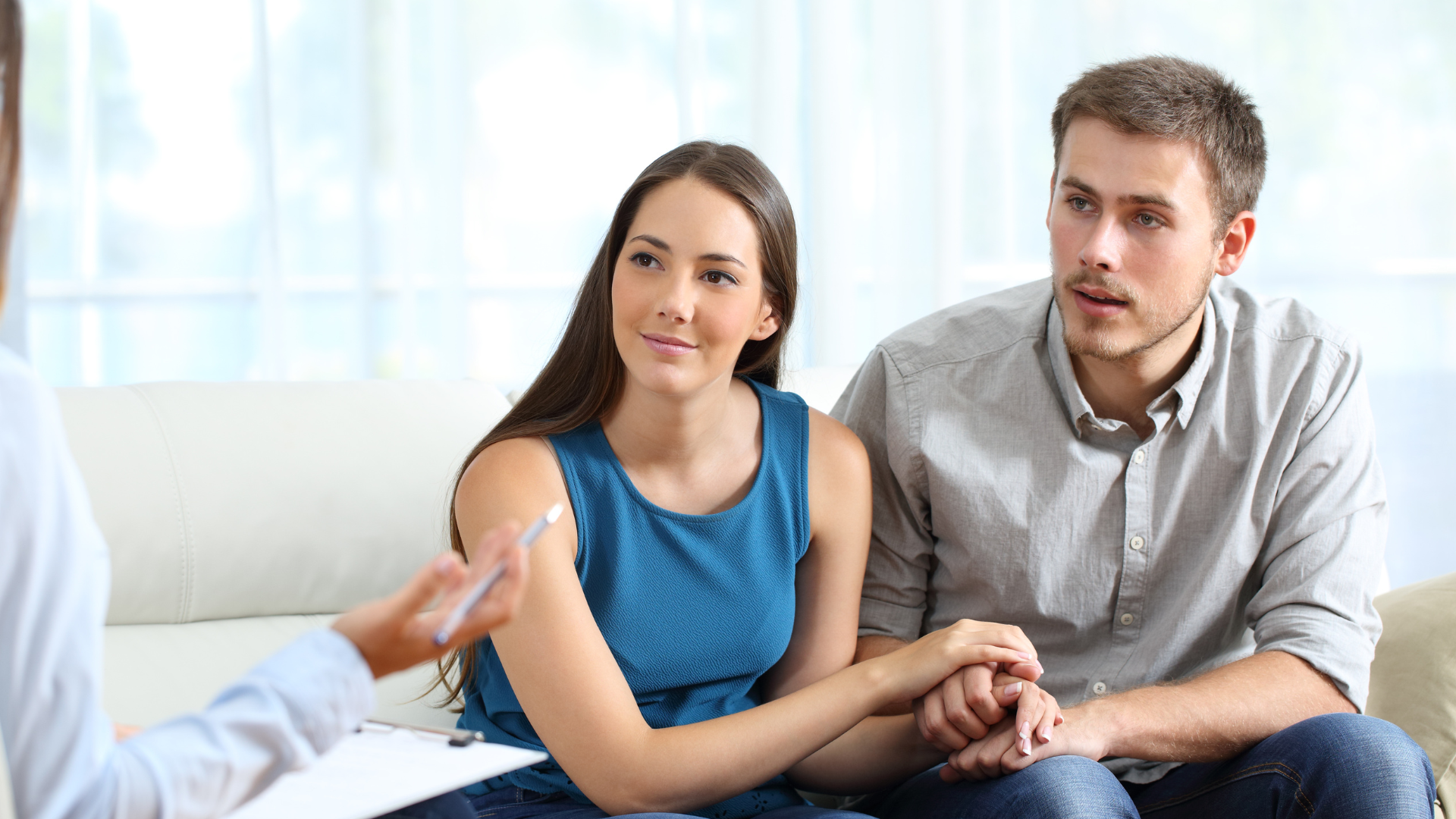 Woman lying on a couch, looking up, with a therapist holding a clipboard.
