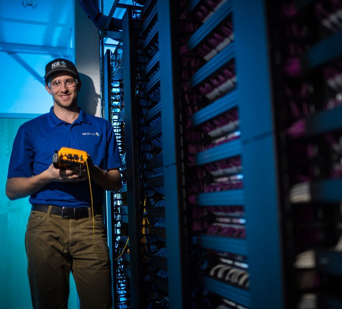 A man in a blue shirt is holding a yellow device