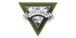 A city of adak logo in a green triangle on a white background.