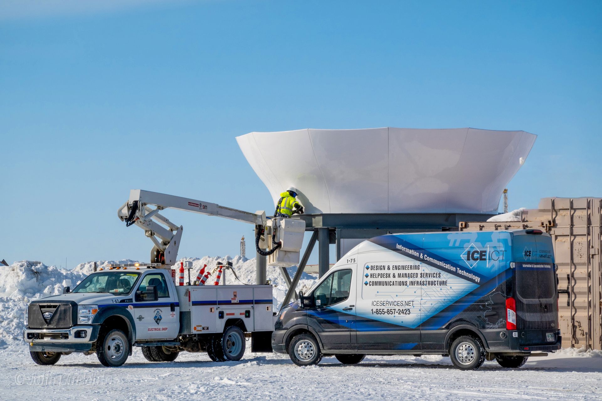 Two trucks are parked next to each other in the snow.