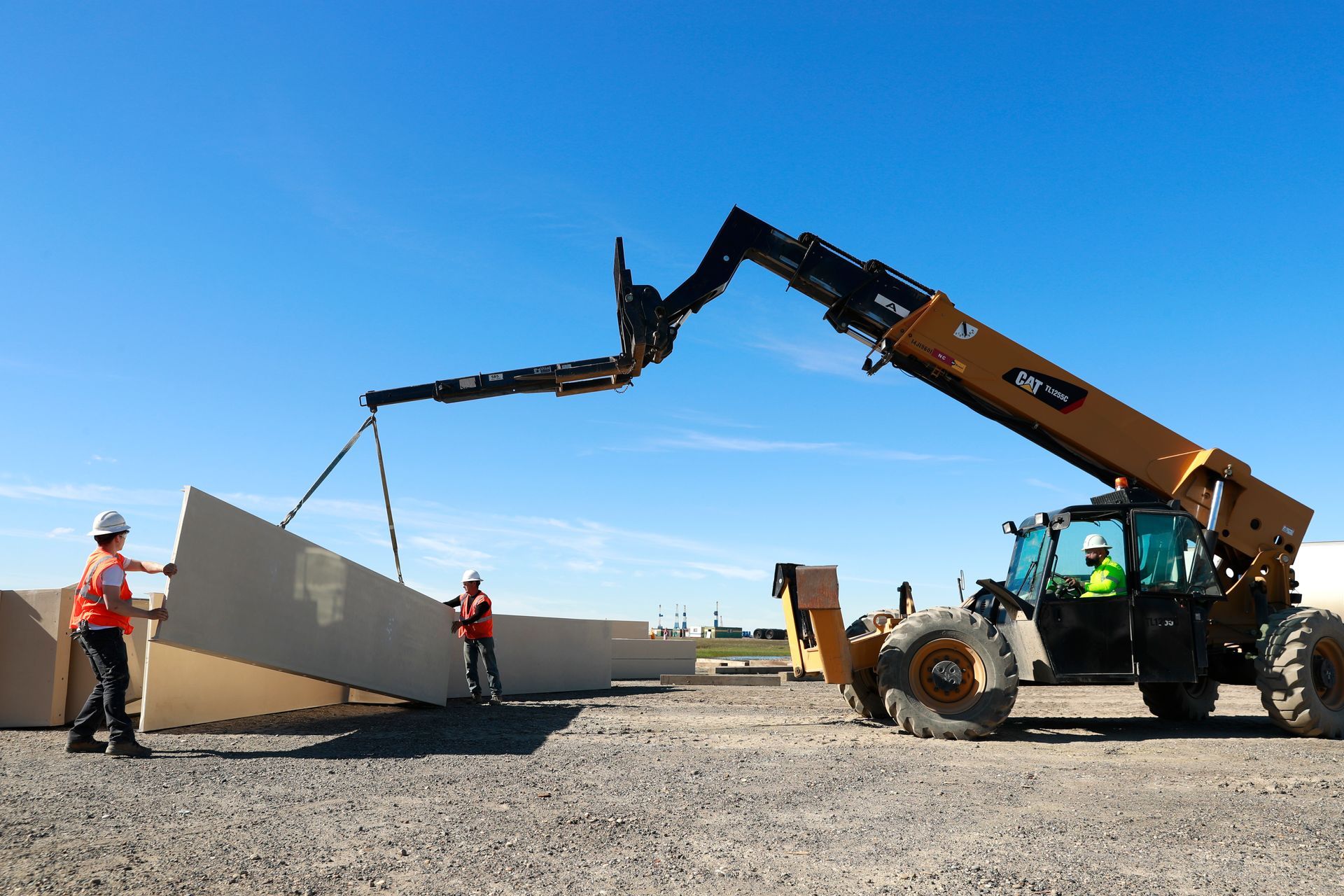 A forklift is lifting a large piece of concrete on a construction site.