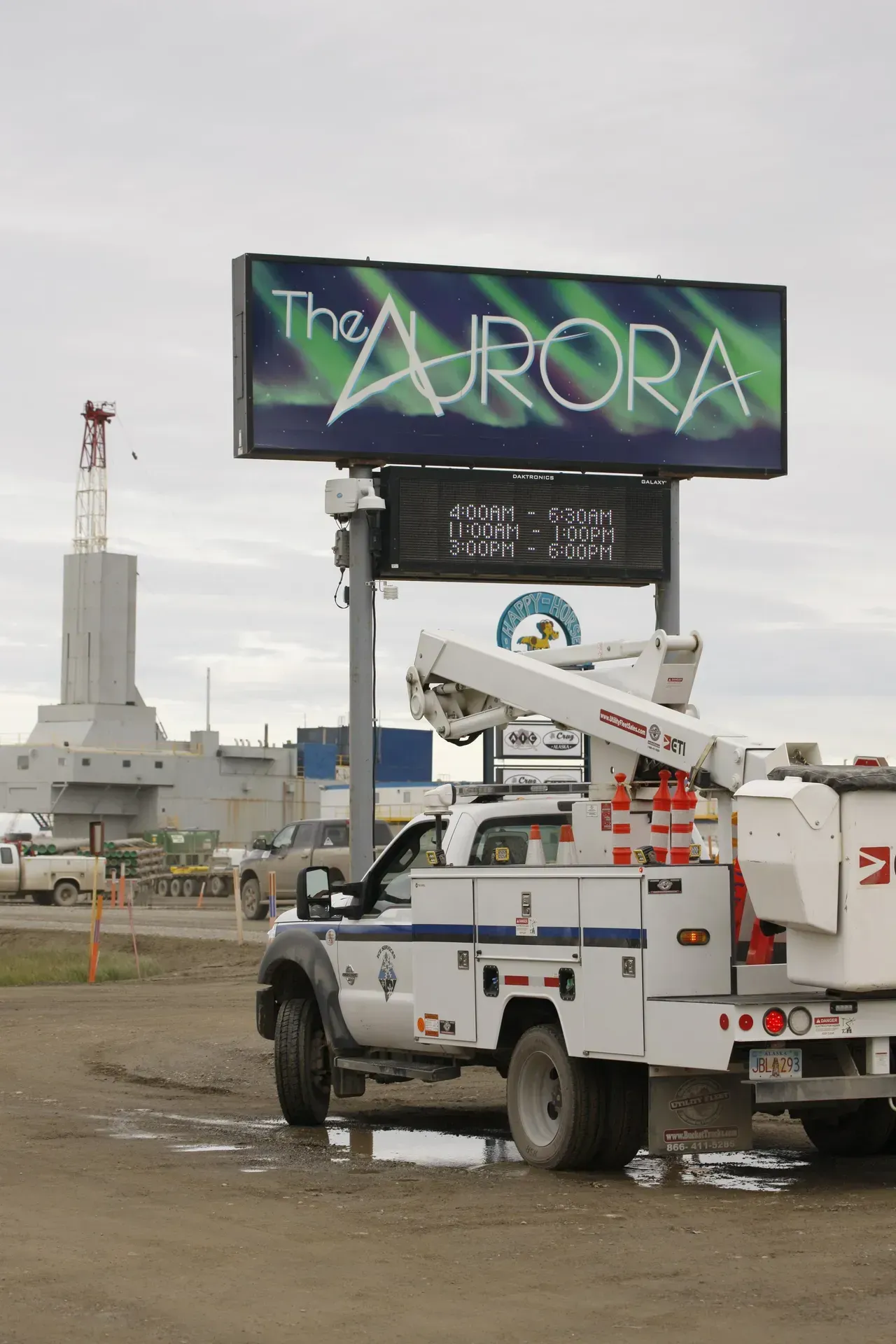 A truck is parked in front of a sign that says the aurora
