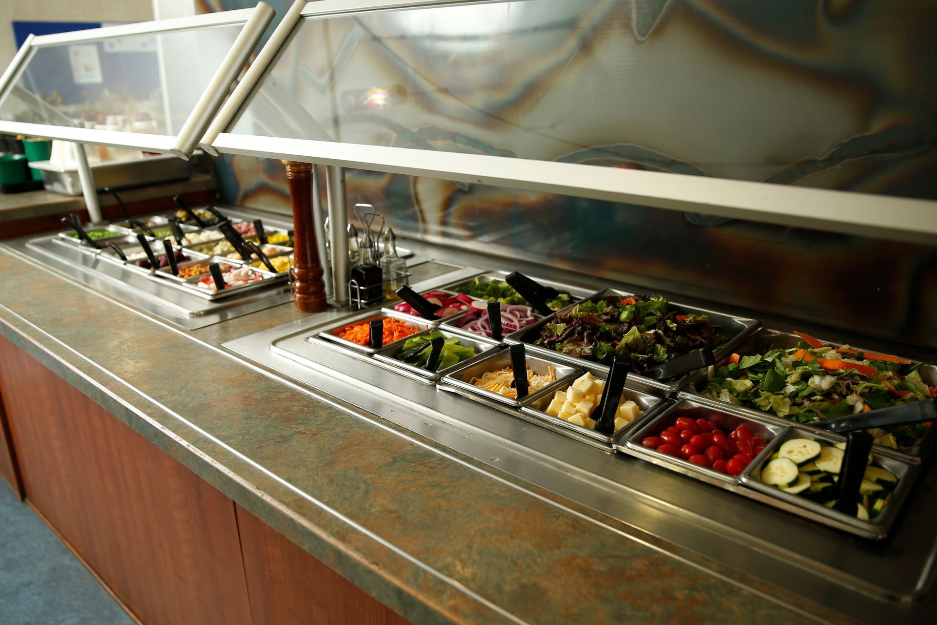 A buffet filled with lots of vegetables and salads