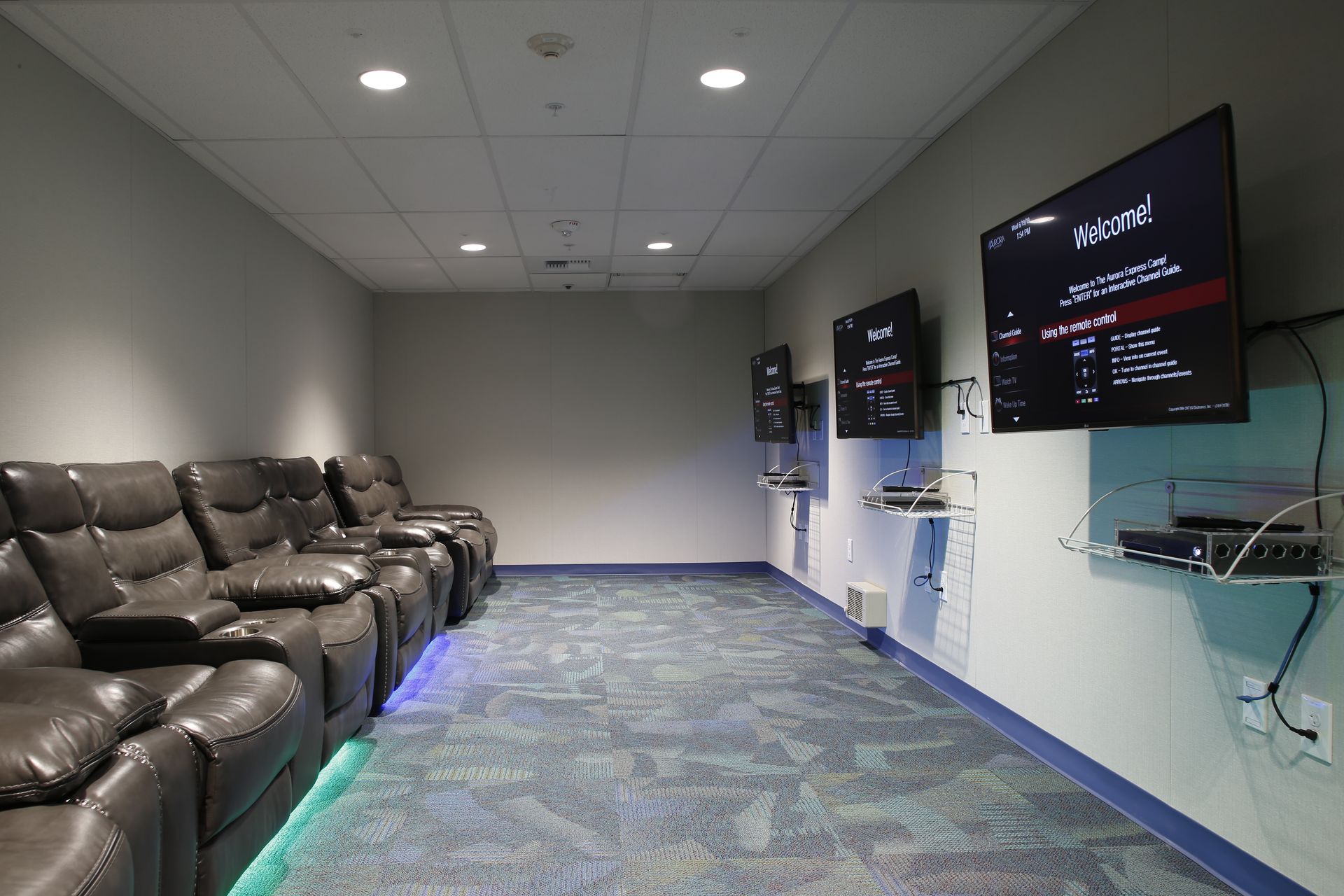 A room with a lot of chairs and televisions on the wall