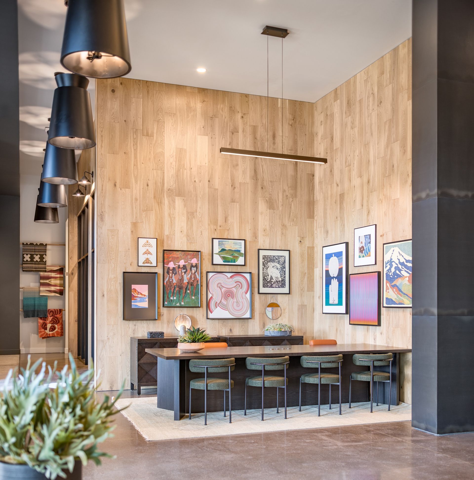 Reception area with wood paneling, artwork, and a long table with chairs.