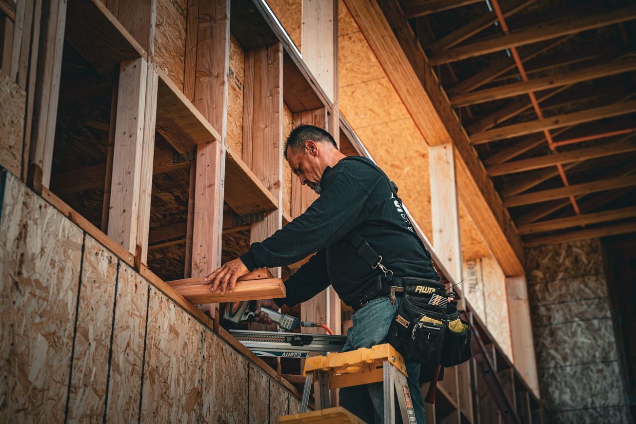 Construction worker installing wood framing inside a house under construction