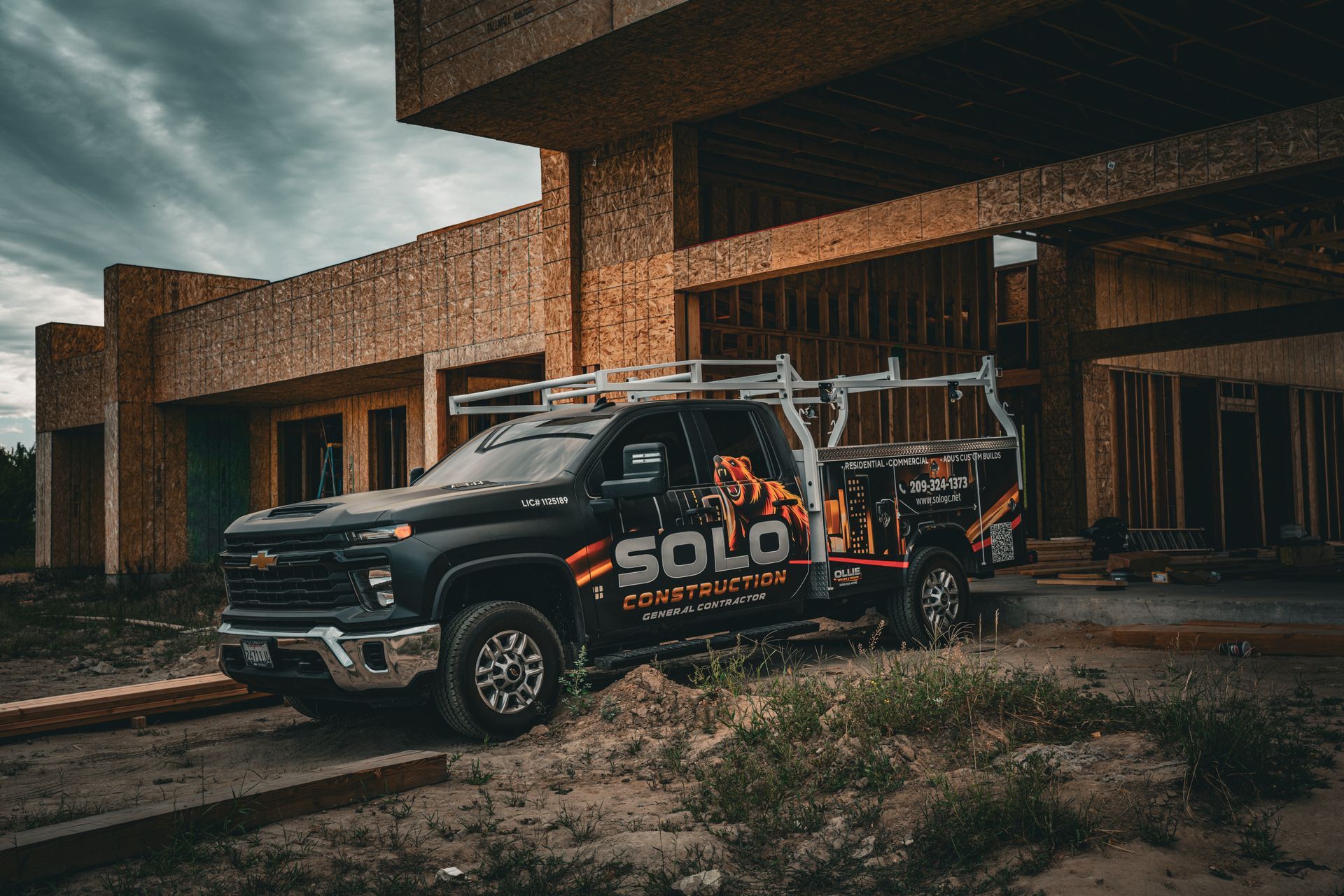 Black utility truck with “SOLO” branding parked outside a modern building.
