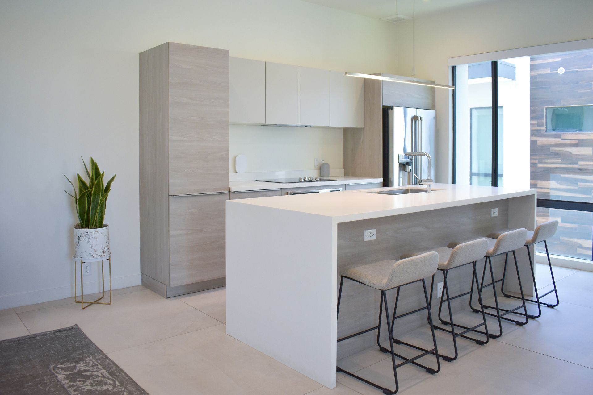 Modern kitchen with white island, bar stools, and stainless steel appliances
