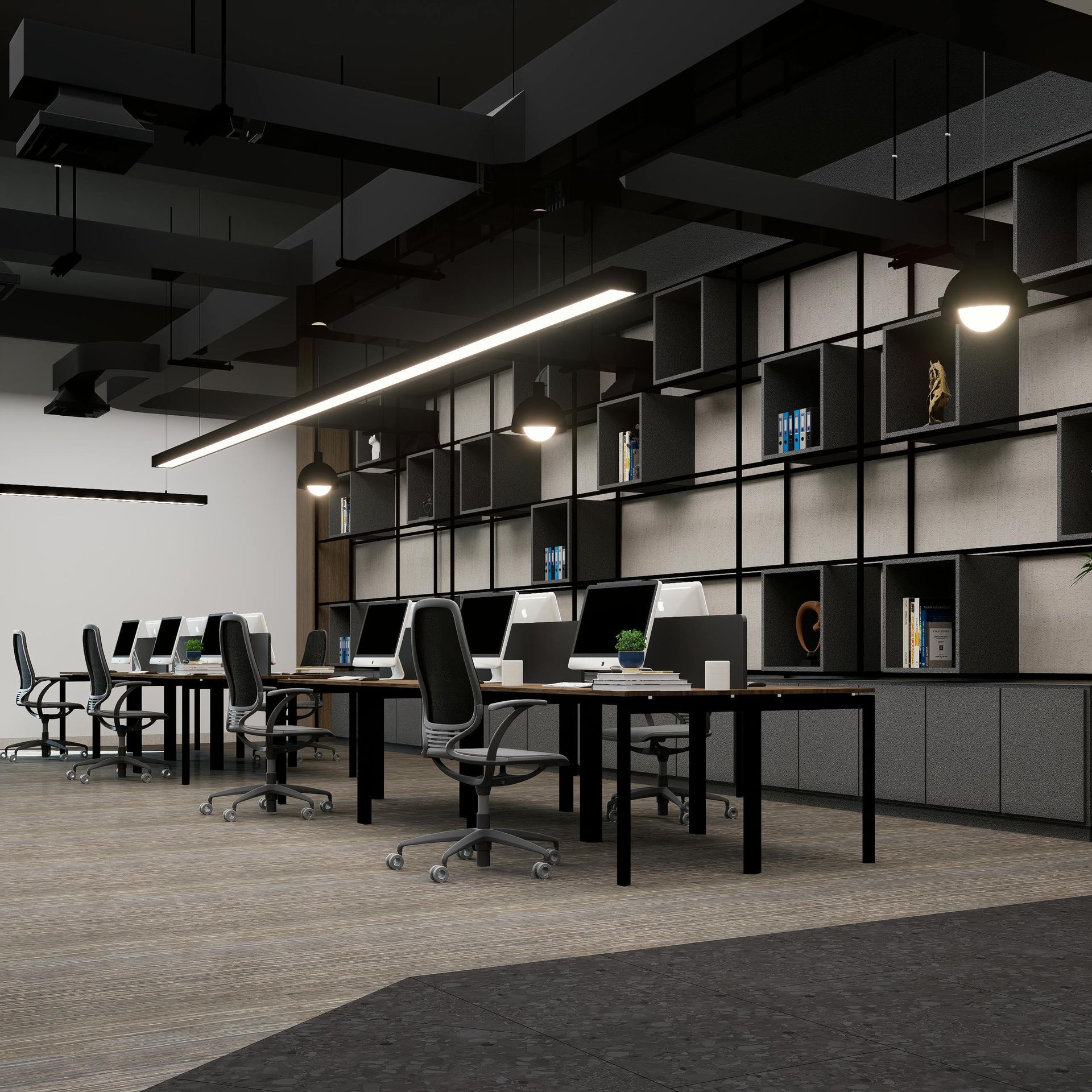 Modern open office with desks, black shelving, task chairs, and pendant lights on a gray carpet