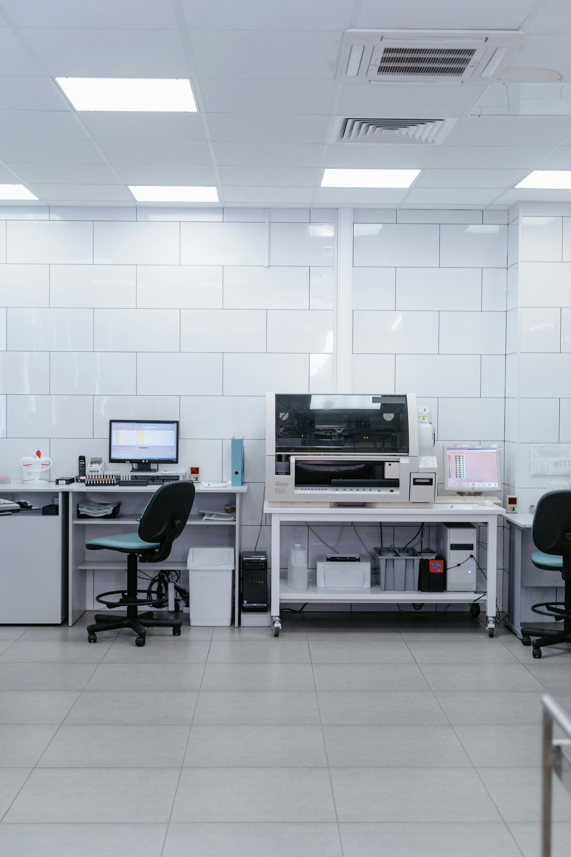 Modern lab or office with desks, computers, chairs, and bright overhead lighting