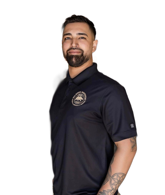 Man in navy polo shirt standing against a white background