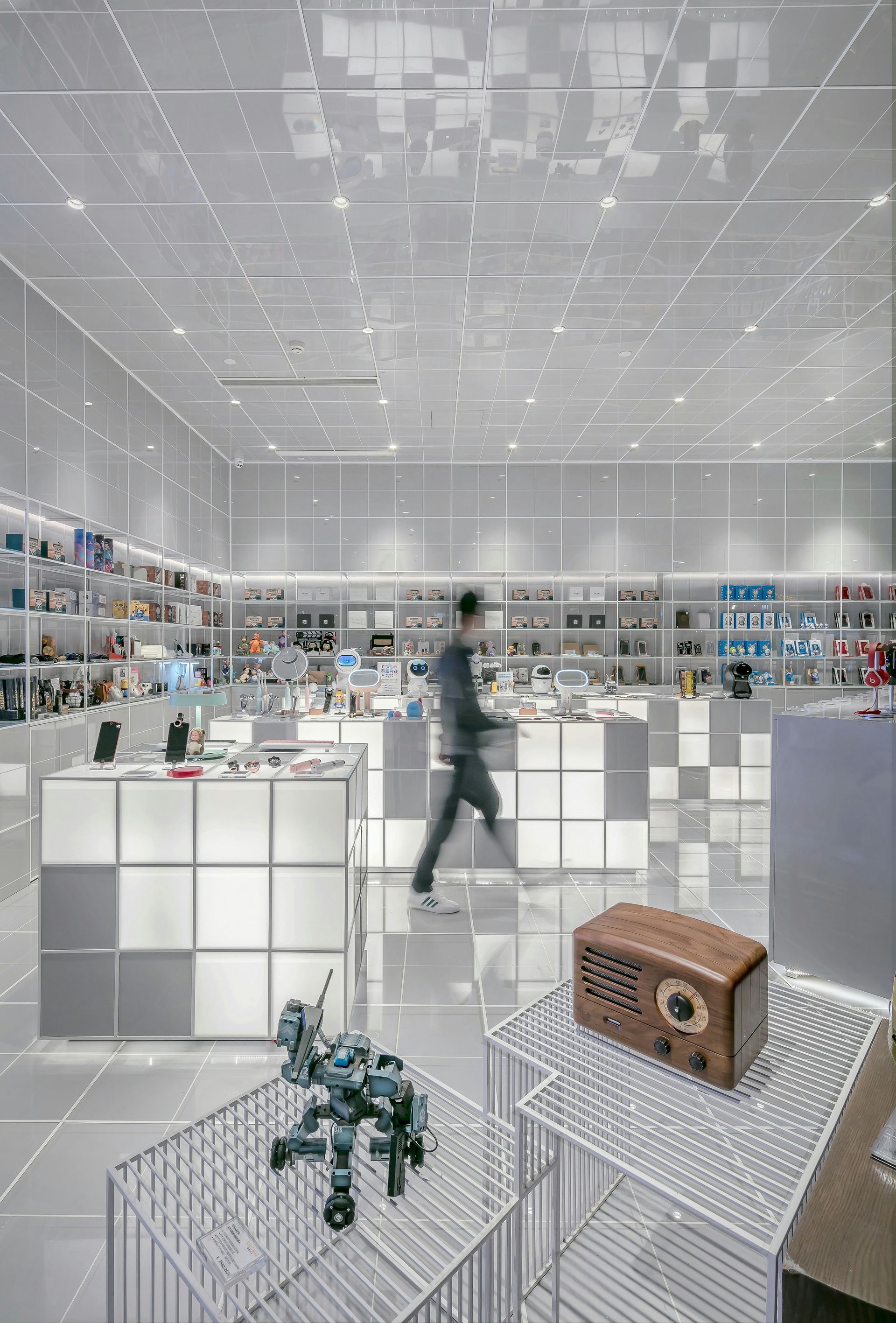 Bright modern retail store with white shelves, a person browsing, and a small wicker basket on a display table