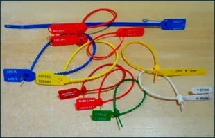 Varios precintos de seguridad de colores, a prueba de manipulaciones, sobre una superficie de madera.