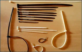 Surtido de bridas blancas y negras, de diferentes tamaños, dispuestas sobre una superficie.