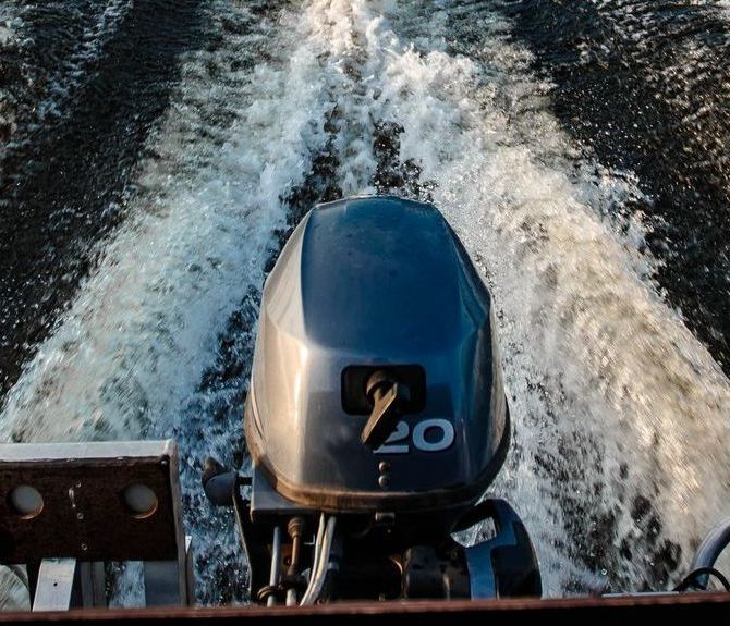 A boat with three outboard motors is docked in the water.