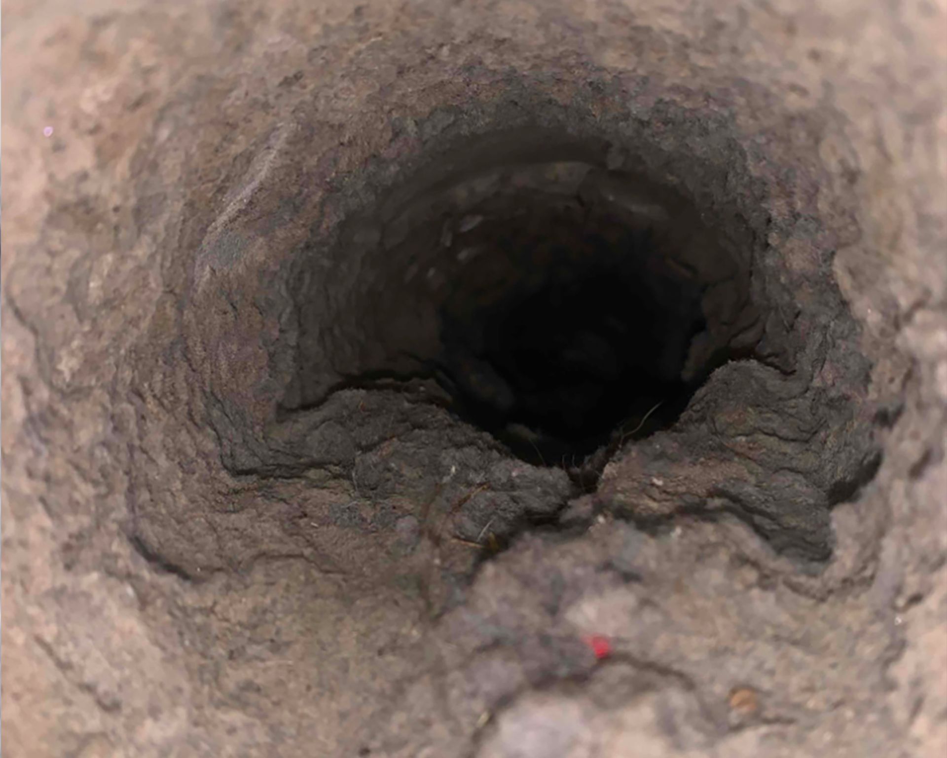 A close up of a hole in a concrete wall.