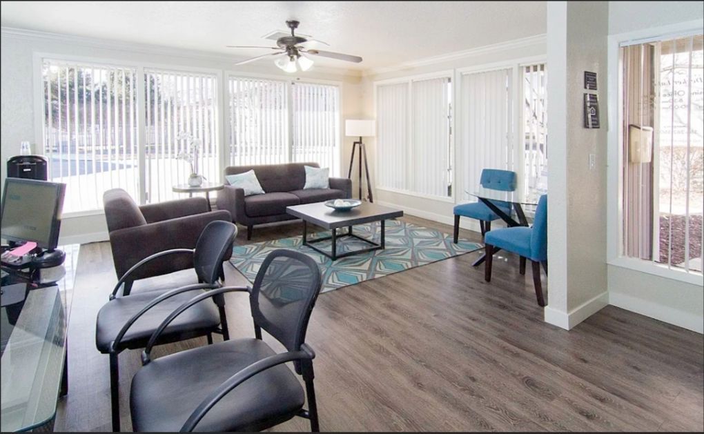 a living room with a couch , chairs , and a ceiling fan .