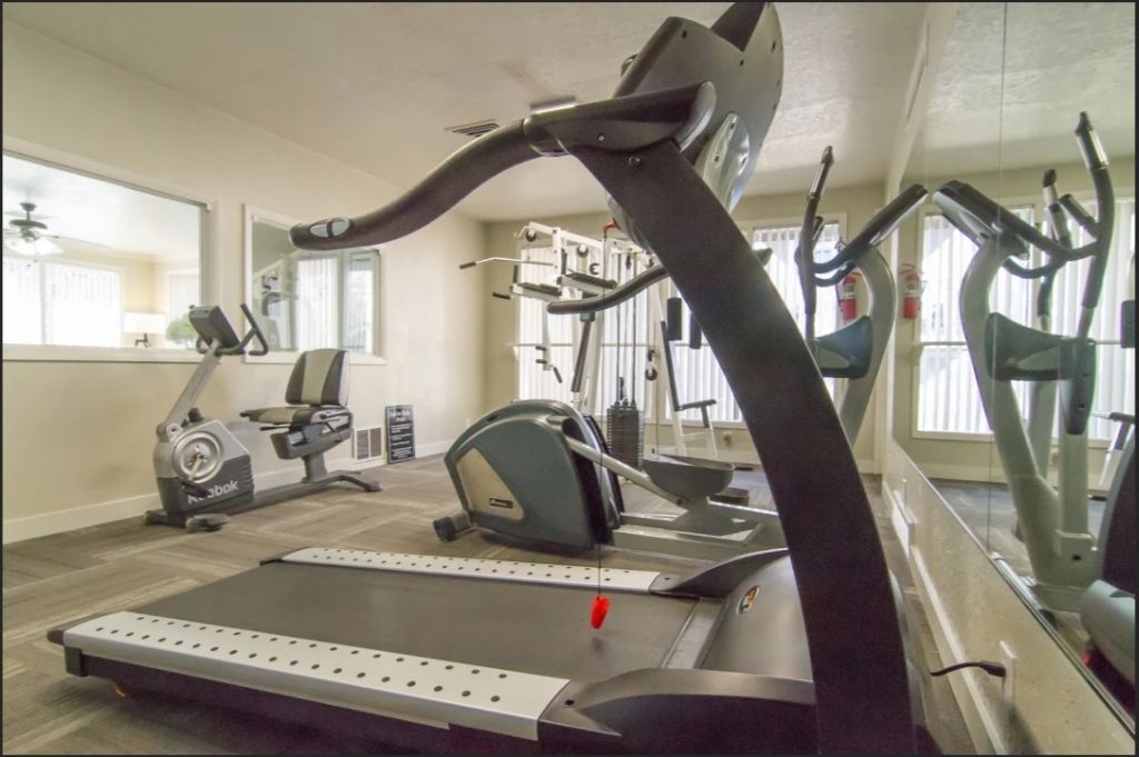 a treadmill is sitting in a gym next to a mirror .