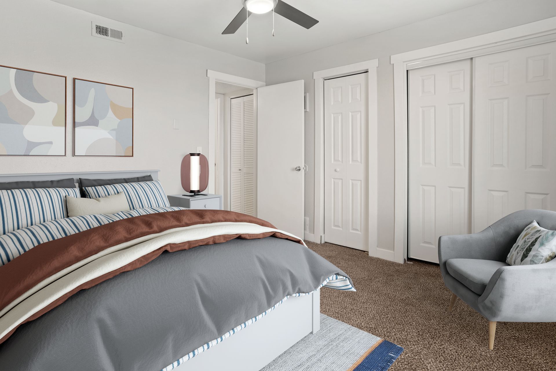 a bedroom with a bed , chair and ceiling fan .