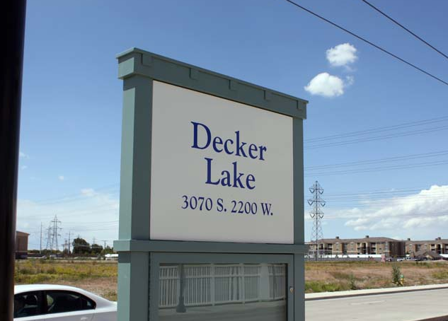 a sign for decker lake is on the side of the road