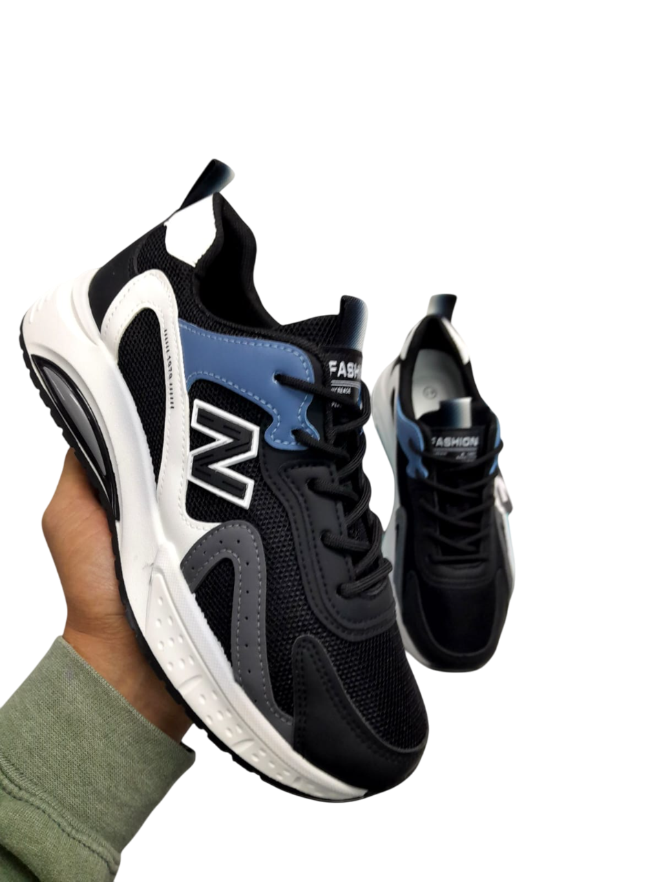 Una mano sosteniendo un par de zapatillas grises y azul marino con detalles en blanco.