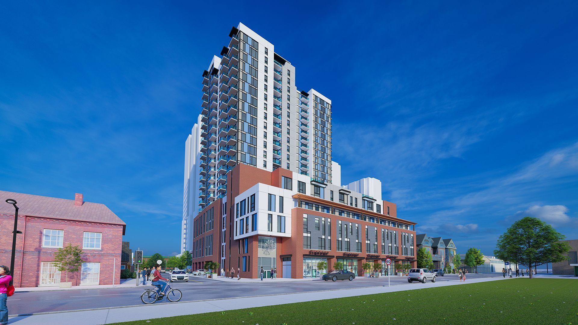 High-rise building with brick facade, townhouses, and a grassy area under a clear blue sky.