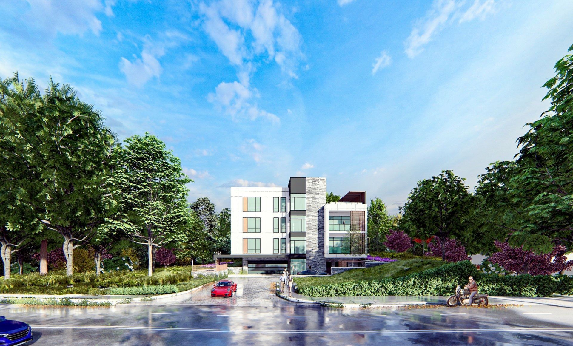 Modern building with white and gray exterior, surrounded by trees and greenery. Bright sky, car in front.