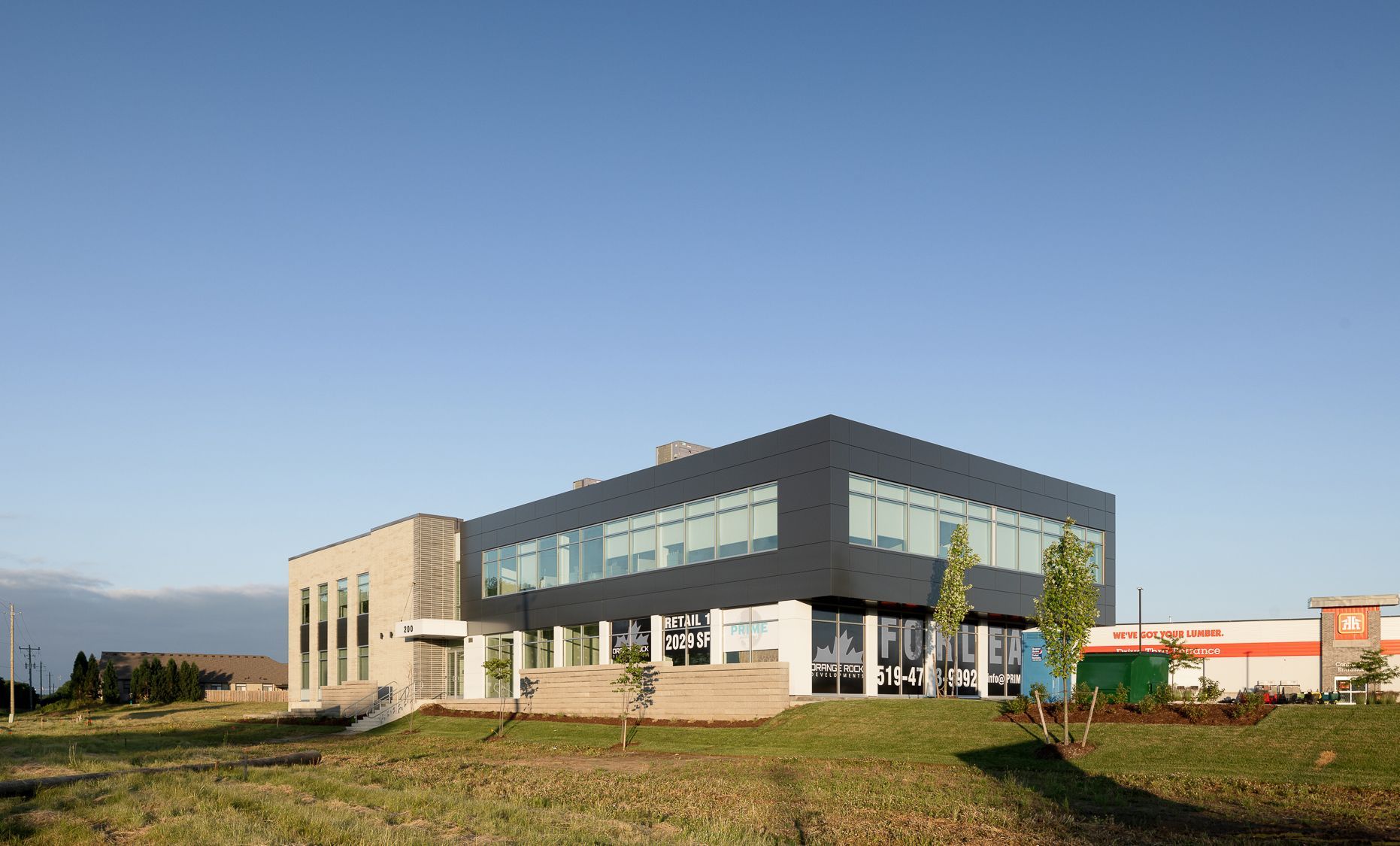 Bird's-eye view model of a commercial area with a roundabout, retail stores, parking, and buildings.