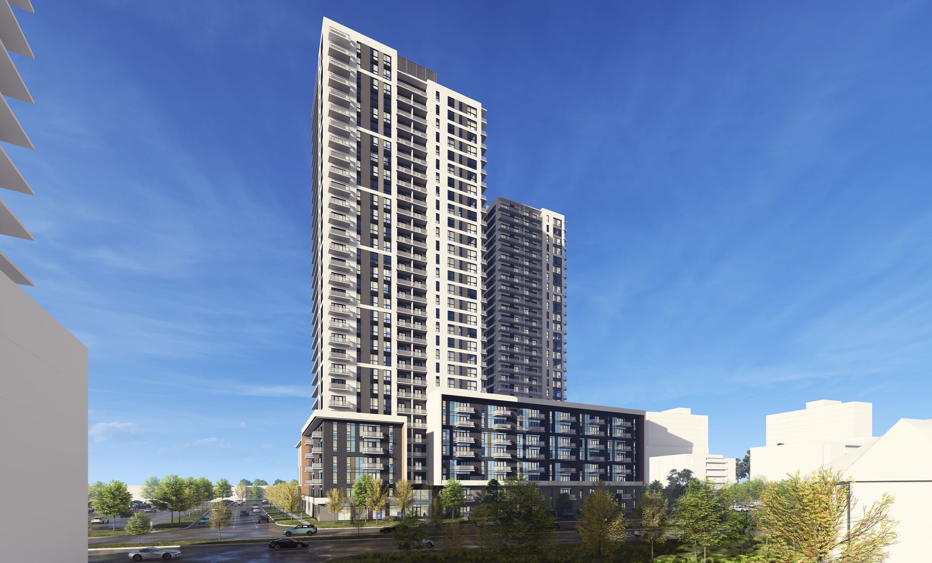 High-rise apartment buildings against a blue sky with a low-rise connecting structure, trees, and building visible.