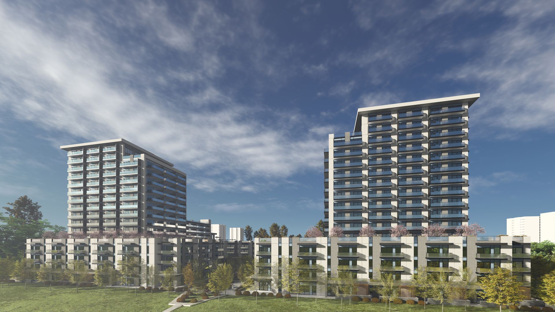 Two modern high-rise buildings with balconies set against a blue sky and a grassy foreground.