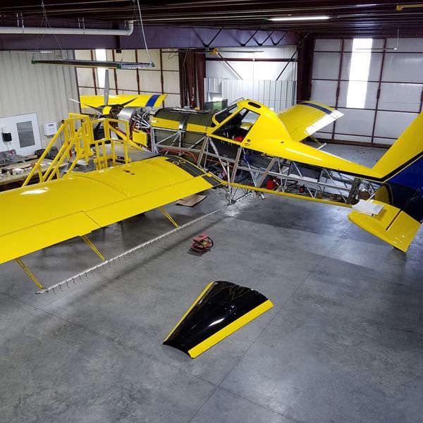 A yellow and black plane is sitting in a hangar