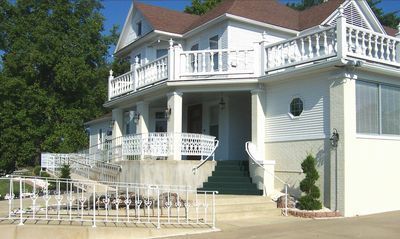 White two-story building with a brown roof and a ramp leading to the entrance.