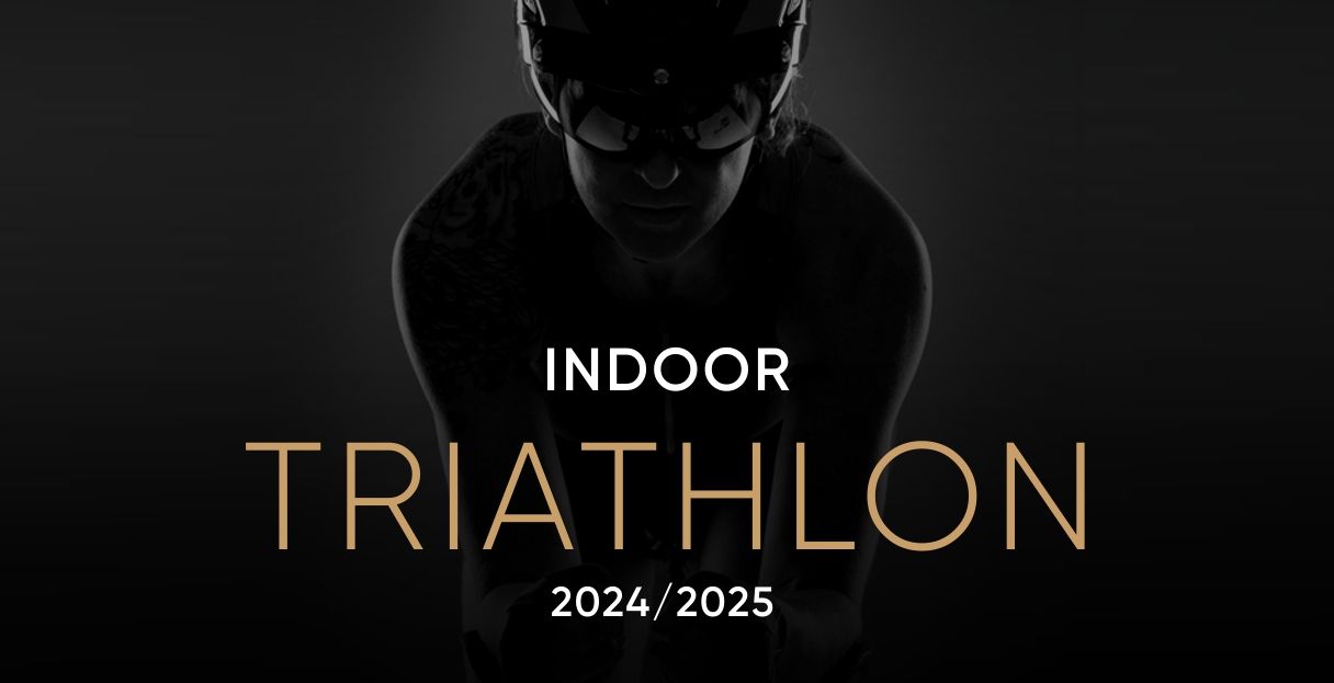 Osoba pływa w basenie, nad którym widnieje napis „triathlon kryty”.