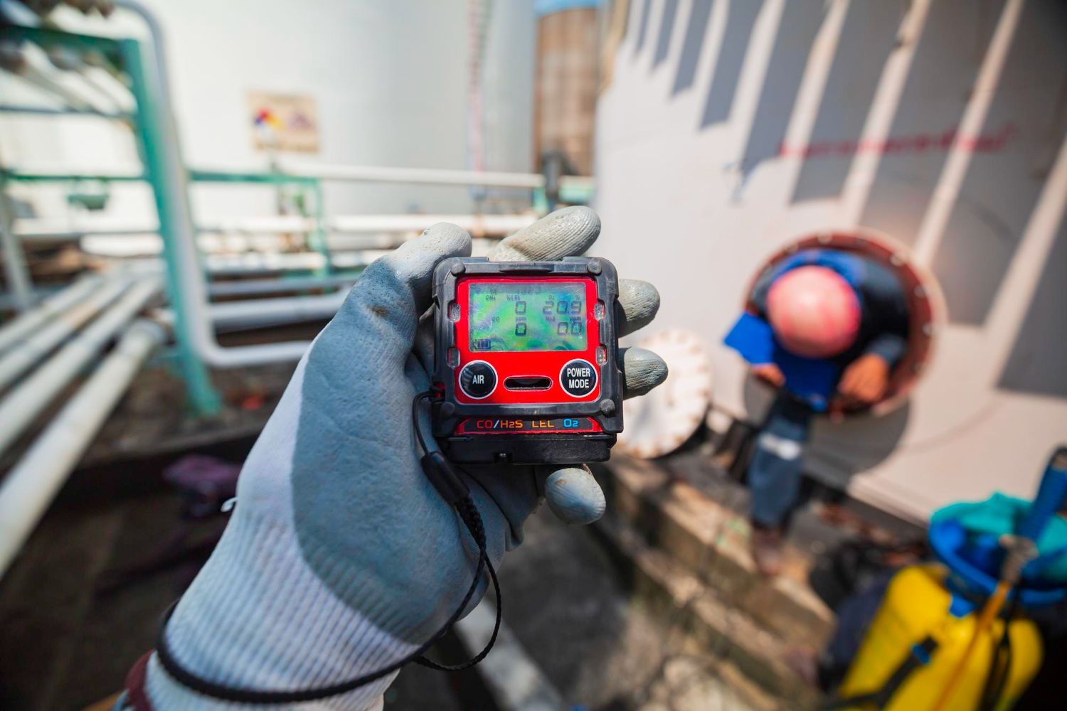 A person is holding a gas detector in their hand.