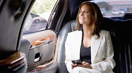A businesswoman travelling in the back of a hire car