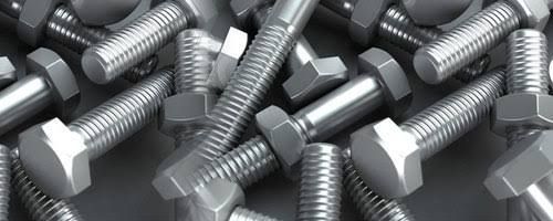 A pile of stainless steel bolts and nuts on a table.