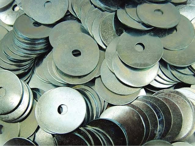 A pile of metal washers with a hole in the middle