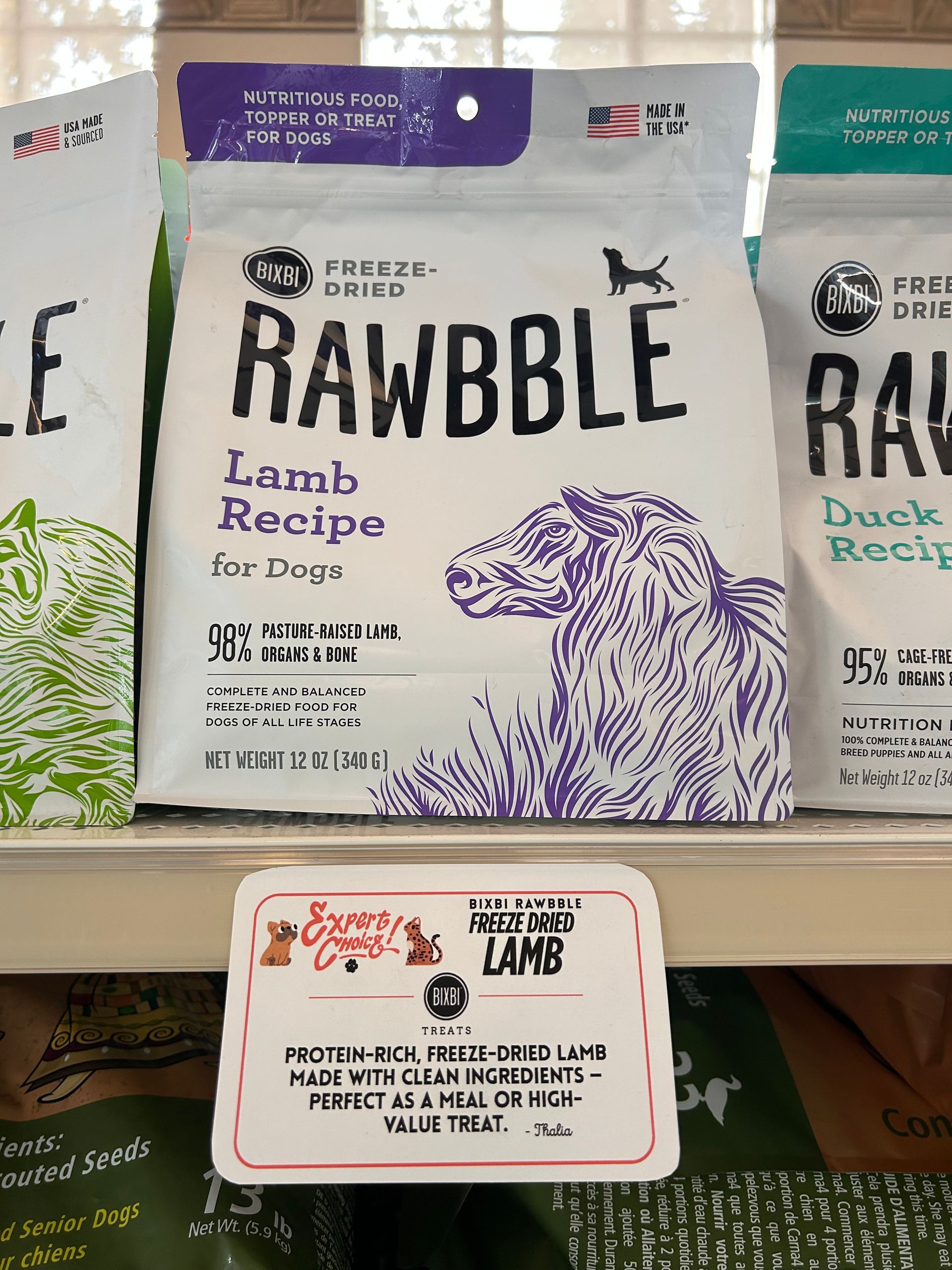 A dog is sitting next to a bunny mascot in front of easter eggs.